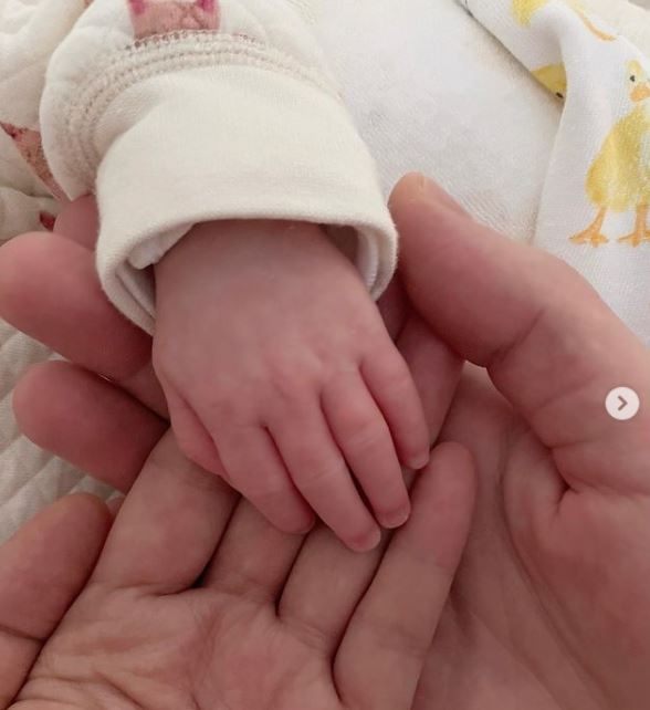 Fala Chen's newborn baby's hand along with her husband's