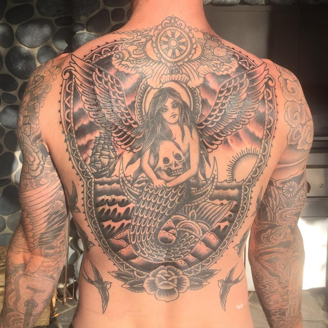 Adamâ€™s back covered with mermaid tattoo