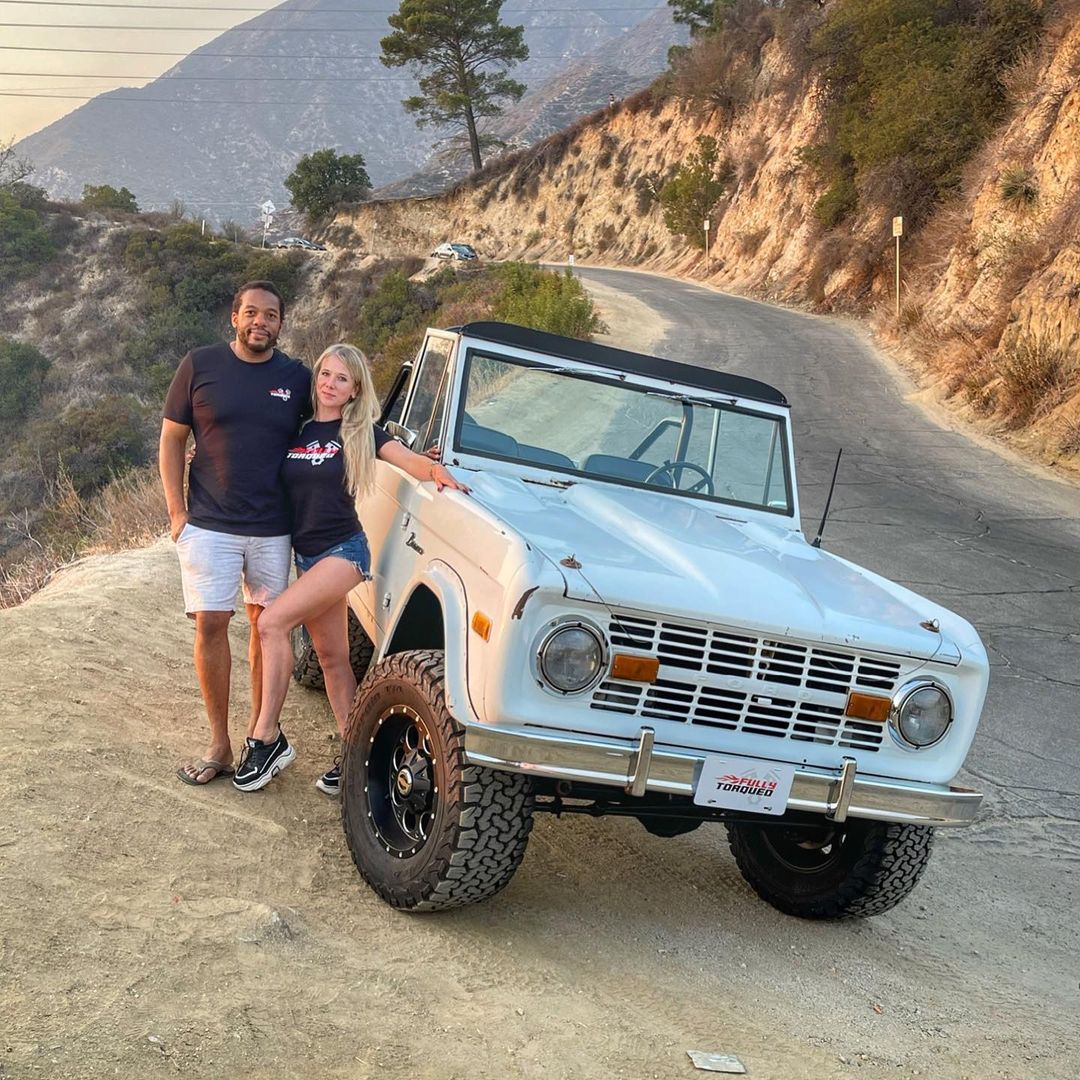 Herb and his wife posing beside the renovated Bronco