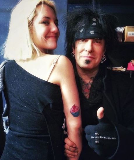 Nikki Sixx with his daughter showing off their matching cupcake tattoos